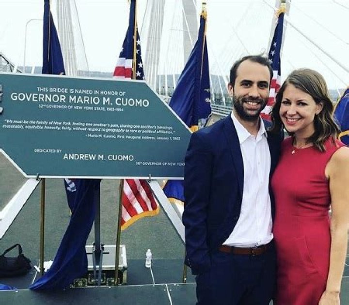 Melissa DeRosa posing in front of a bridge memorial with husband Matthew Wing